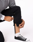 Woman zipping Casual Zip Pants over brace