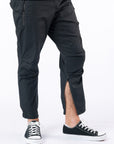 Male model wearing black casual zip pants with ankle zipper open