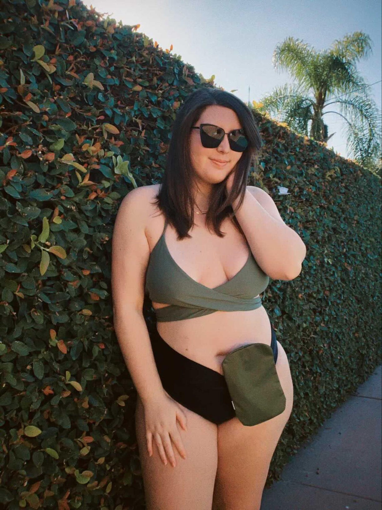 Woman in bathing-suit wearing olive elastic ostomy bag cover