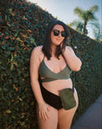 Woman in bathing-suit wearing olive elastic ostomy bag cover