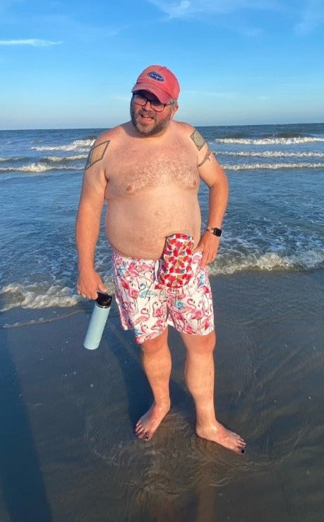 Man on beach wearing Hibiscus elastic ostomy bag cover