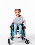 Gracie in a wheelchair wearing a pink Raglan Access Tee on a white background