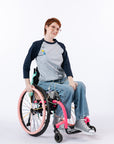 Woman in wheelchair wearing Raglan Access Tee. Text reads "Katelyn is 5'6" wearing a size S".