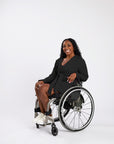 Woman in wheelchair wearing black Adult Chest Access Fleece Wrap Top