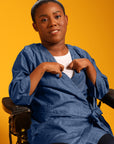 Woman in wheelchair wearing blue Adult Chest Access Chambray Wrap Top