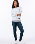 Celia wearing Reverse Triple Zip Crewneck Sweatshirt, text reads "Celia is 5'4" wearing a size M".
