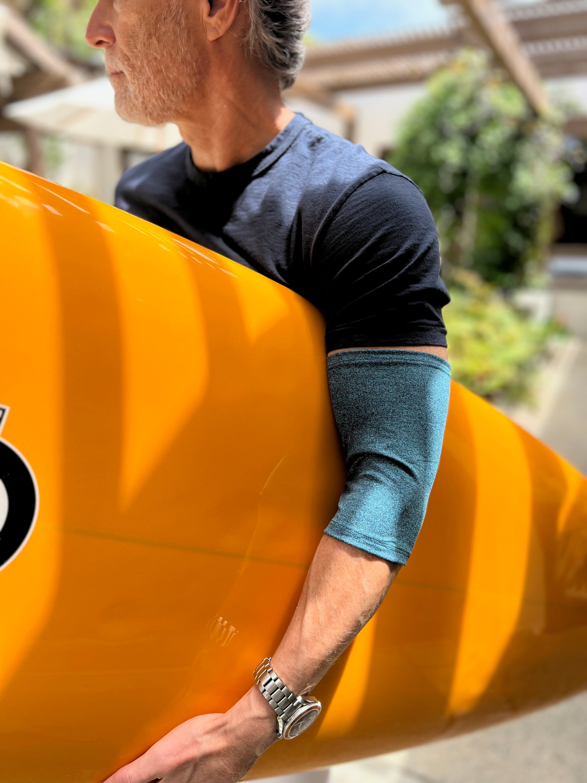 Man with surfboard wearing heathered support sleeve