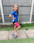 Girl with soccer ball wearing pink heathered support sleeve on leg