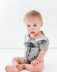 Baby boy in tie dye All Access bodysuit with snaps open