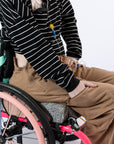 Model putting hand in pant pocket, showcasing front pocket of wheelchair pants