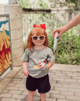 Girl wearing spaceship G-Tube Zip Tee with feeding tube