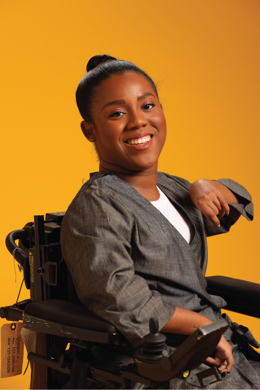 Woman in wheelchair wearing black Adult Chest Access Chambray Wrap Top