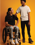 Man in wheelchair wearing black Adult Raglan Chemo Port Access Zip Tee Shirt, man standing wearing gray Adult Raglan Chemo Port Access Zip Tee Shirt
