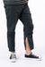Male model wearing black casual zip pants with ankle zipper open