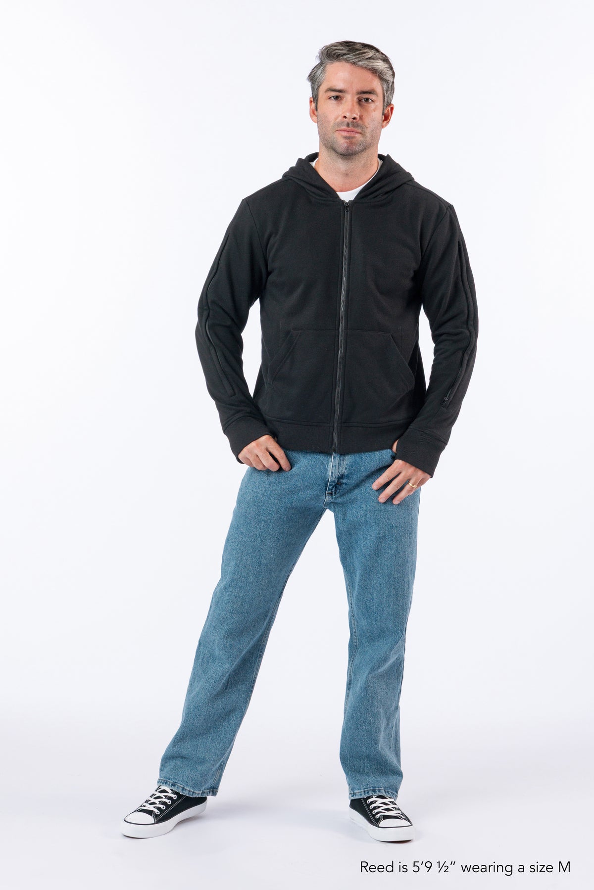 Man wearing Full Zip Hoodie zipped up. Text reads "Reed is 5'9 1/2" wearing a size M".