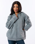 Woman wearing gray Full Zip Hoodie zipped up. Text reads "Celia is 5'4" wearing a size M".