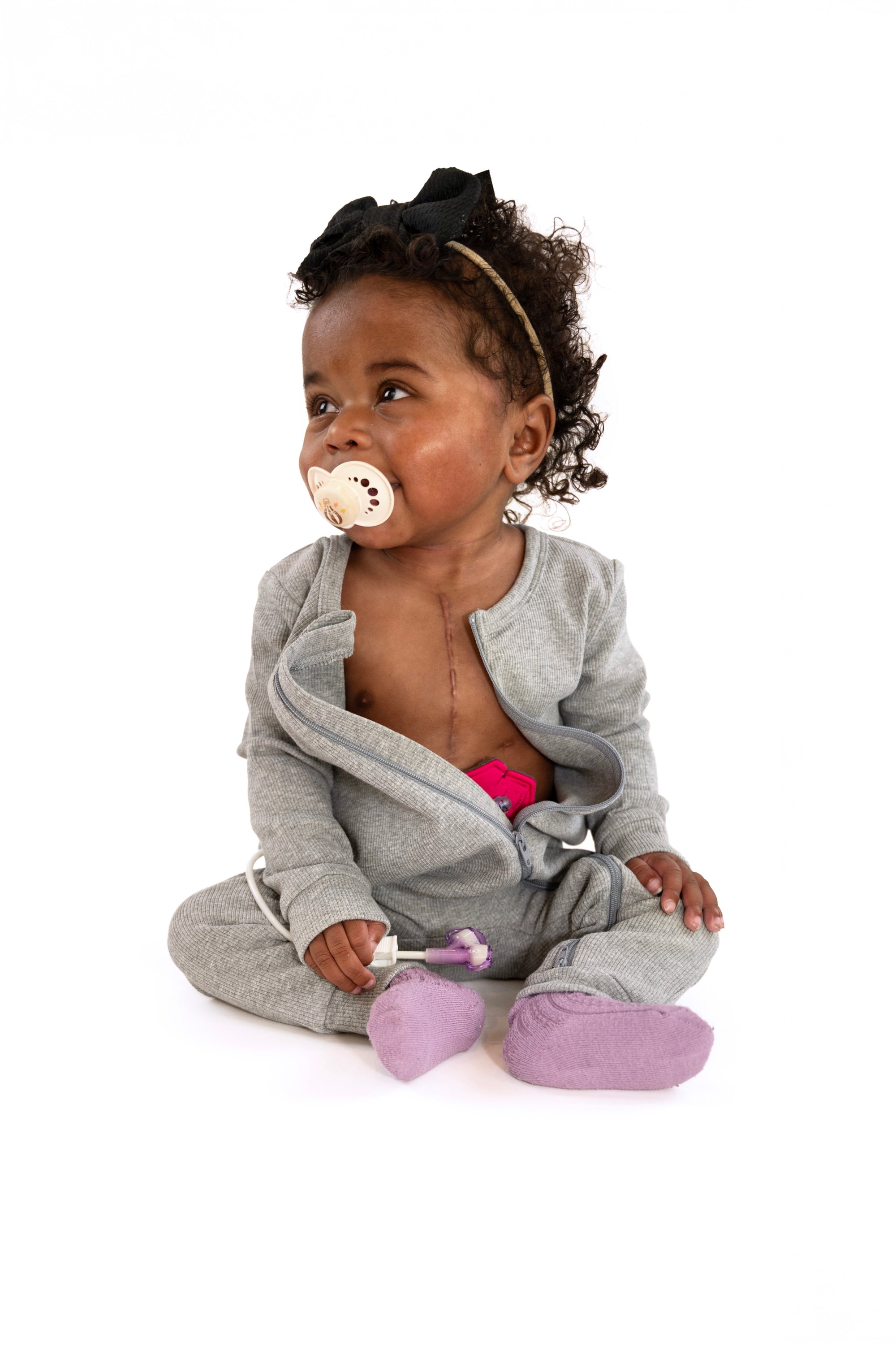 Baby in open Heather Gray Rib G-Tube Pajamas with G-Tube pad showing