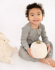 Child wearing Heather Gray Rib G-Tube Pajamas while holding pumpkin