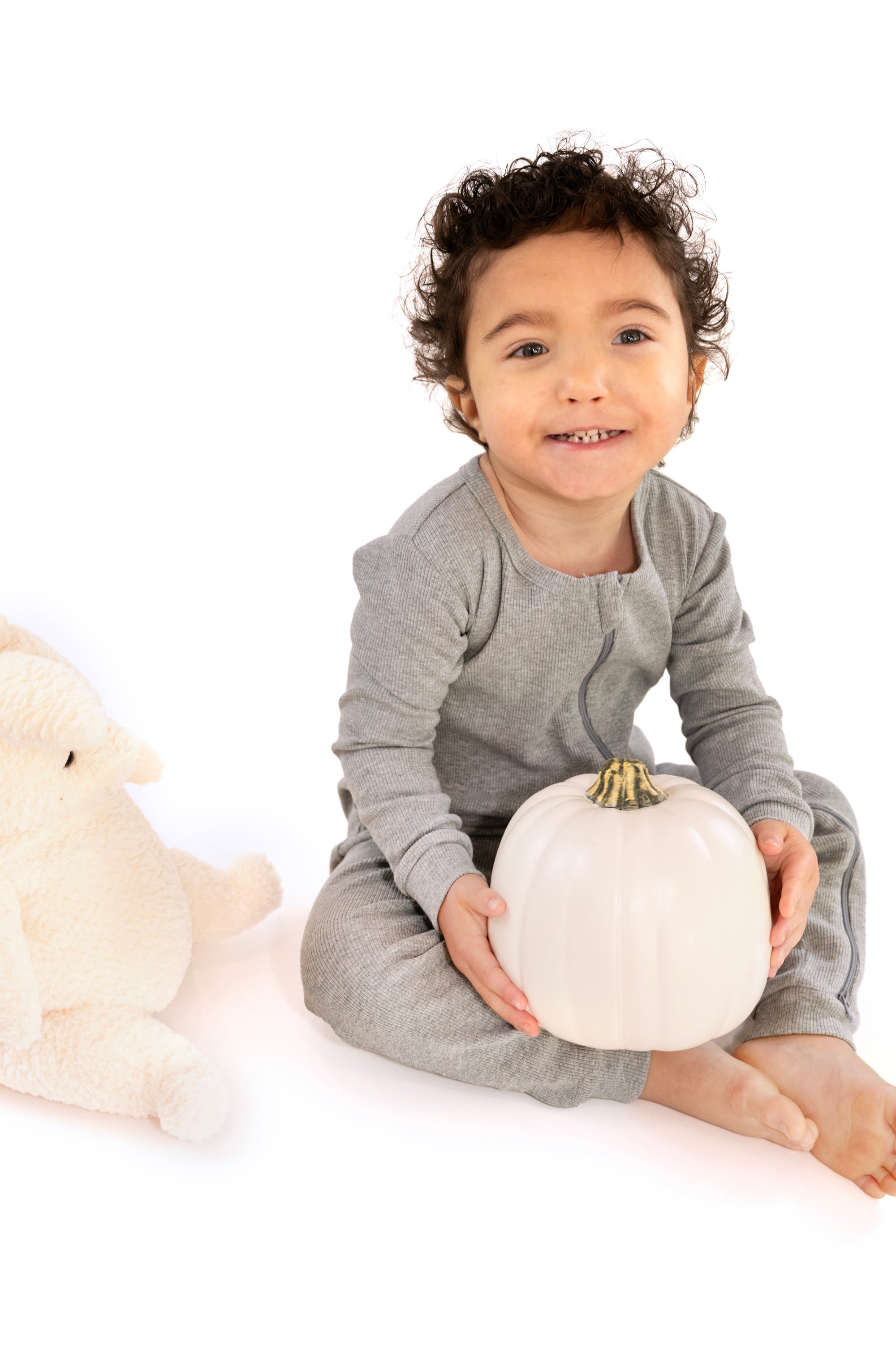 Child wearing Heather Gray Rib G-Tube Pajamas while holding pumpkin