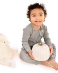 Child wearing Heather Gray Rib G-Tube Pajamas while holding pumpkin