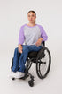 Woman in wheelchair wearing purple Raglan Access Tee