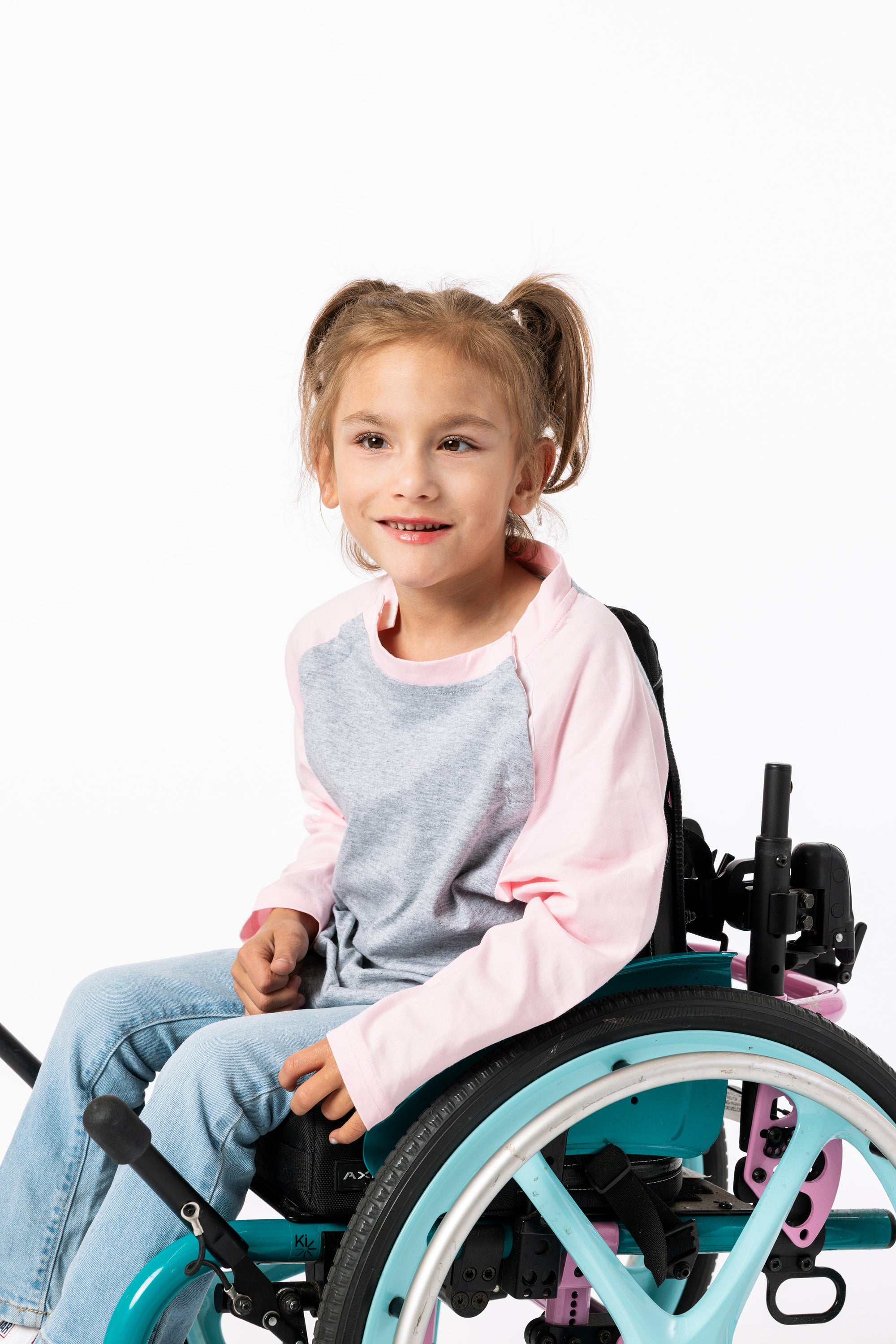 Gracie wearing Pink Raglan Access Tee in wheelchair