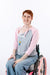 Female model in wheelchair posing with open chest snaps, showing chest port