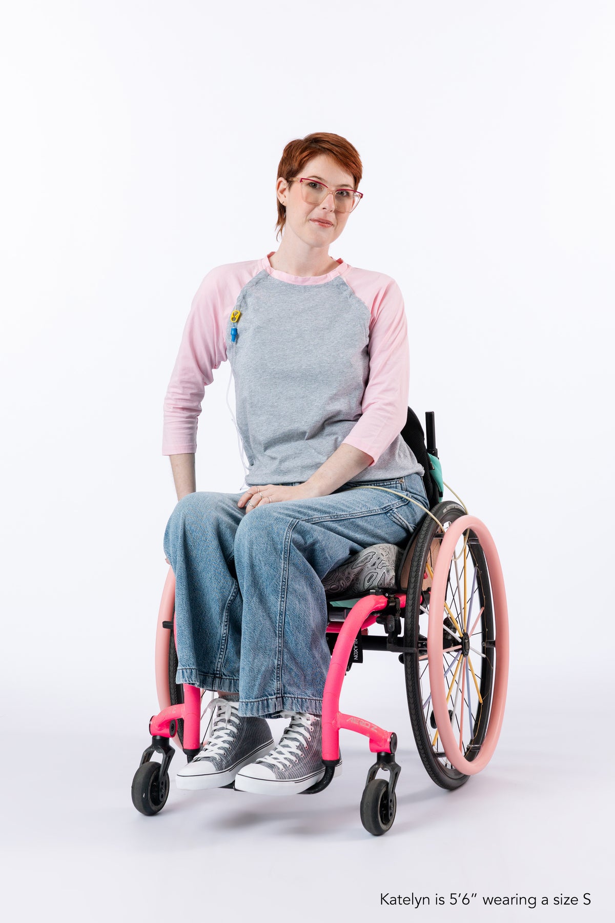 Woman in wheelchair wearing pink Raglan Access Tee