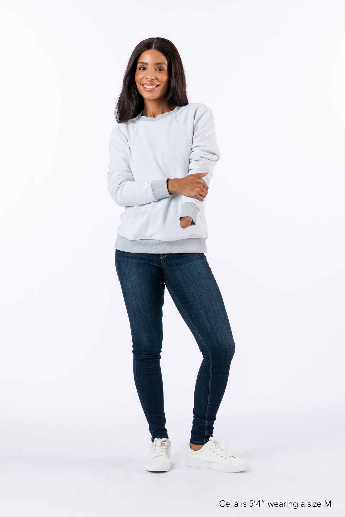 Celia wearing Reverse Triple Zip Crewneck Sweatshirt, text reads "Celia is 5'4" wearing a size M".
