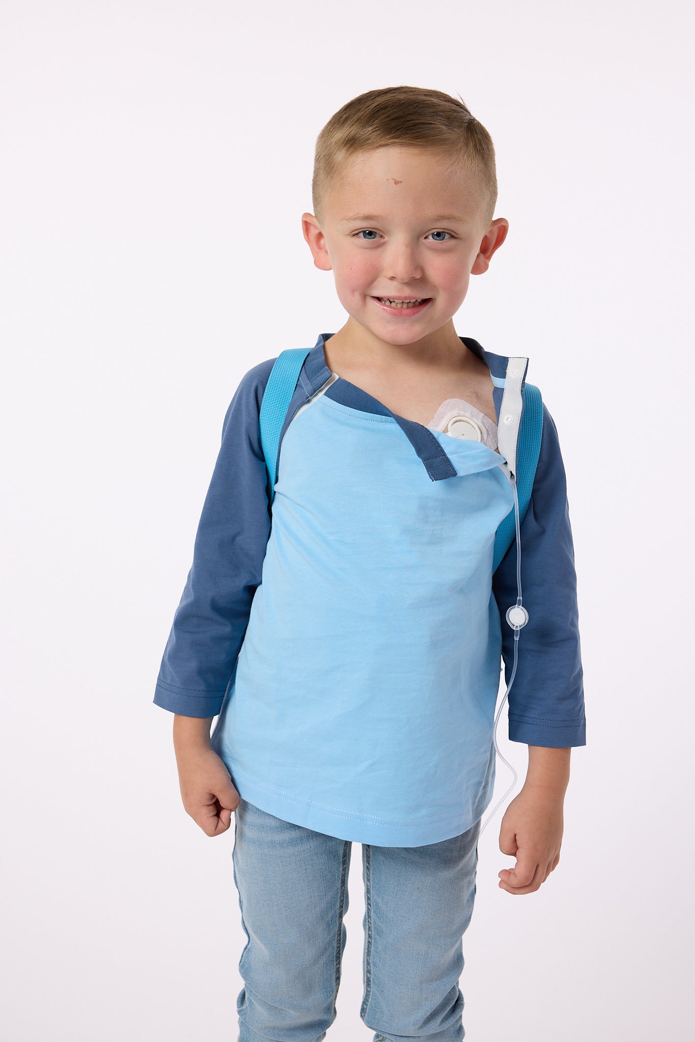 Finley wearing blue CB Kids Raglan Access Tee with open snaps, showing chest port