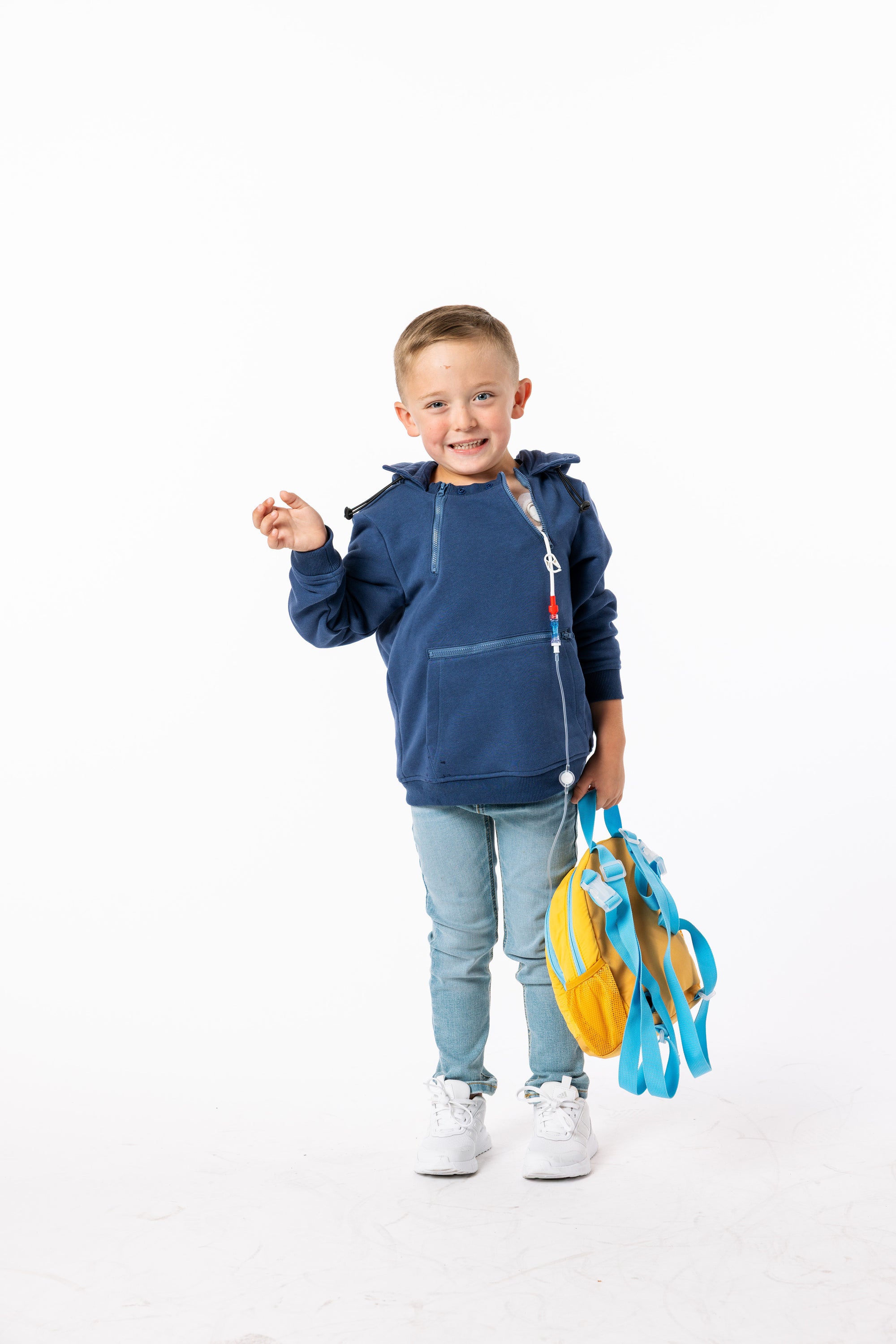 Child wearing a blue hoodie with medical device 