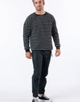 Man wearing Chest Zip Access tee and casual zip pants. Text reads "Reed is 5'9 1/2" wearing a size M".