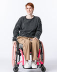Woman in wheelchair wearing Chest Zip Access Tee. Text reads "Katelyn is 5'6" wearing a size M".