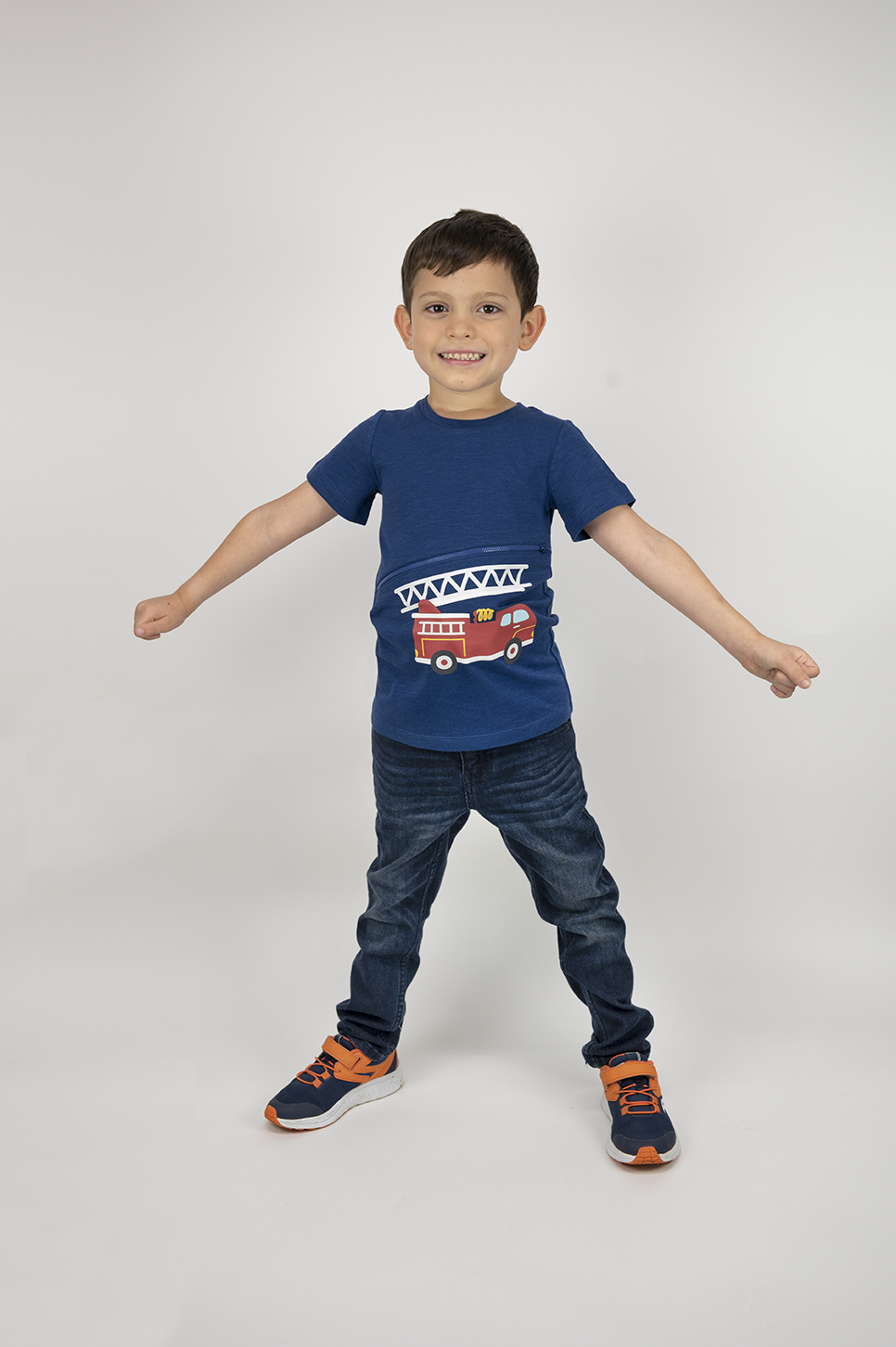 Boy wearing royal blue firetruck G-tube zip shirt with zipper for abdominal access