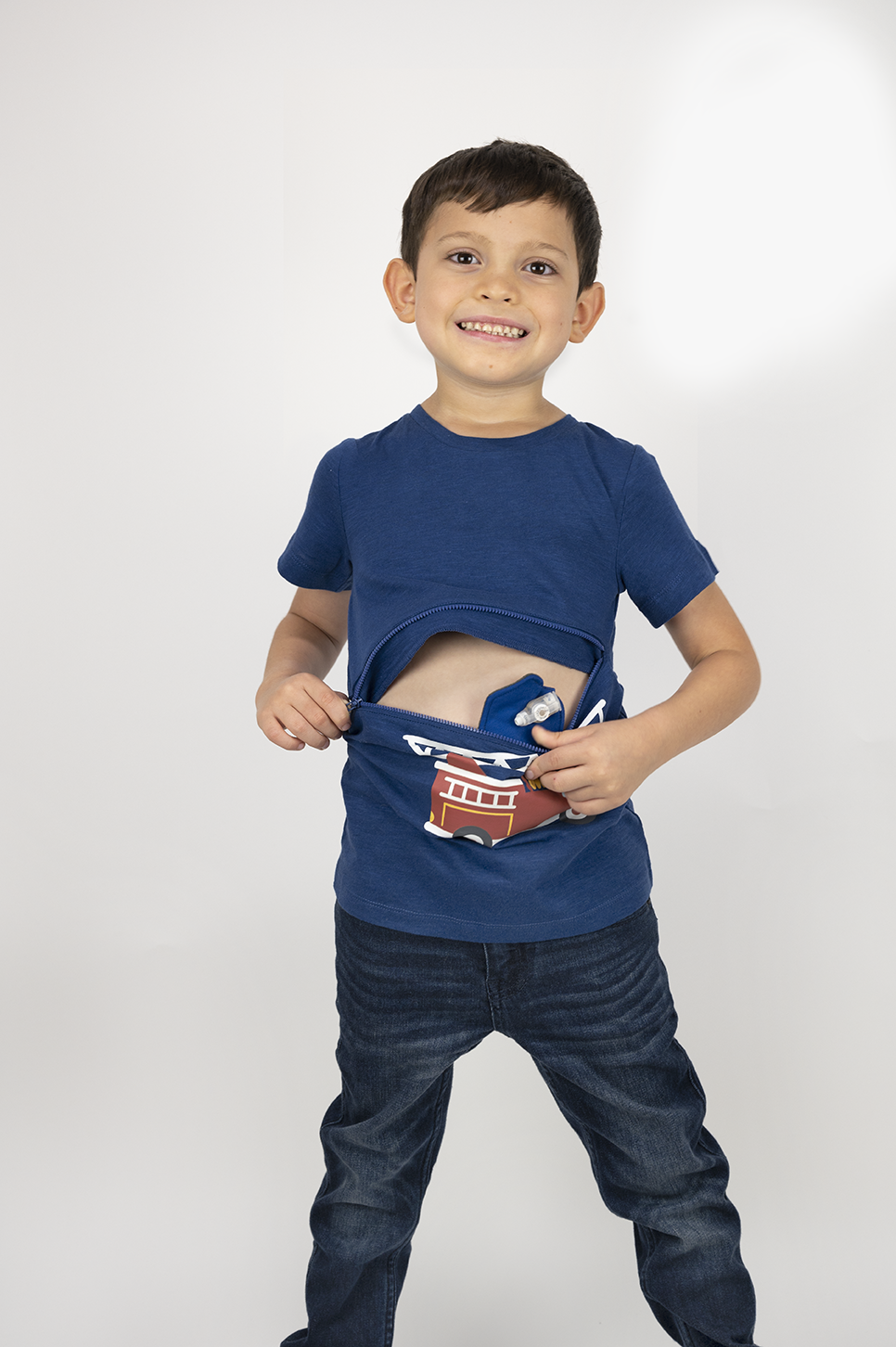 Boy wearing royal blue firetruck G-tube zip shirt with zipper for abdominal access open to show g-tube pad