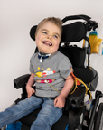 Boy seated in wheelchair wearing Gray Spaceship for Life G-tube zip shirt with zipper for abdominal access open to show g-tube pad