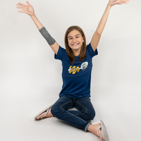 Girl sitting with arms raised wearing Royal Blue Spoonie for Life G-tube zip shirt with zipper for abdominal access